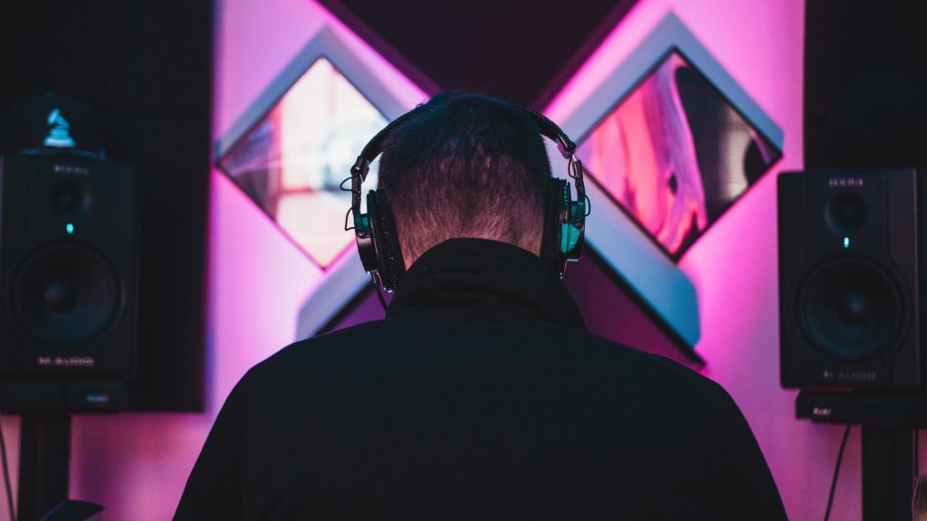 Visual of male figure in a studio with dramatic lighting - music production.